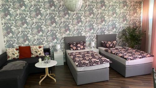Zimmer mit 2 Betten, einem Sofa und einem Tisch in der Unterkunft RoseMarie in Gotha