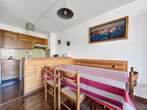 une cuisine avec une table, deux chaises et un comptoir dans l'établissement GR007 - 2 Pièces 5/6 pers centre Carroz, aux Carroz d'Arâches