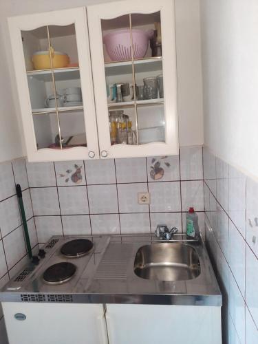 a kitchen with a sink and white cabinets at MaroVito in Supetarska Draga