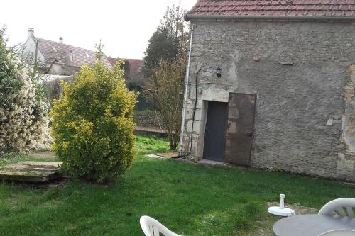 un antiguo edificio de piedra con una puerta en un patio en Maison de campagne à 2h de Paris, en Andryes