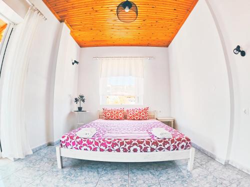 - une chambre avec un grand lit et un plafond en bois dans l'établissement House Charistos, à Neos Marmaras