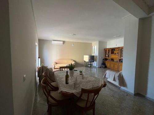 een eetkamer met een tafel en stoelen en een slaapkamer bij Luxury seaside apartment, 3 bedrooms in Livanátai