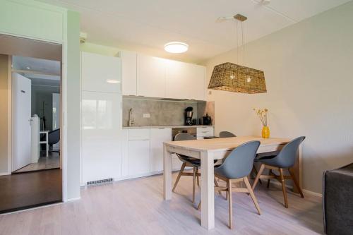 een keuken en eetkamer met een tafel en stoelen bij Beach Appartement 10 - Aan de duinen, Callantsoog aan Zee in Callantsoog