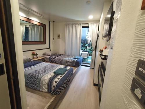 een hotelkamer met 2 bedden en een balkon bij Rangyen Homestay Cha-Am รังเย็น in Cha Am