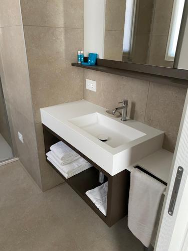 a bathroom with a white sink and a mirror at Petit Hotel in Caorle