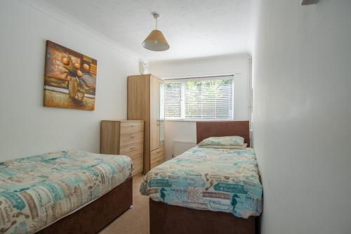 a bedroom with two beds and a window at Kipling Villa With Sea Views in Bideford