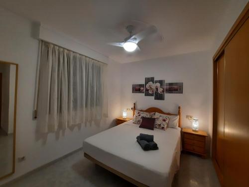a bedroom with a bed and two lamps and a window at Alcossebre RESIDENCIAL ALANDALUS 5002 in Alcossebre