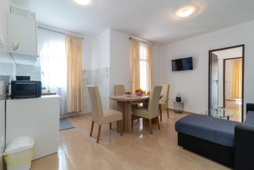 eine Küche und ein Wohnzimmer mit Tisch und Stühlen in der Unterkunft Beachfront apartments Jurica with balcony in Trogir