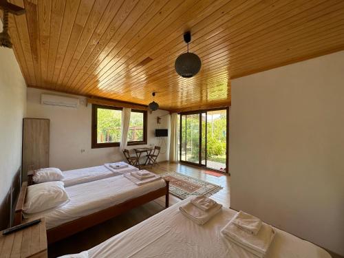 a bedroom with two beds and a wooden ceiling at Incekum Pansiyon in Bodrum City