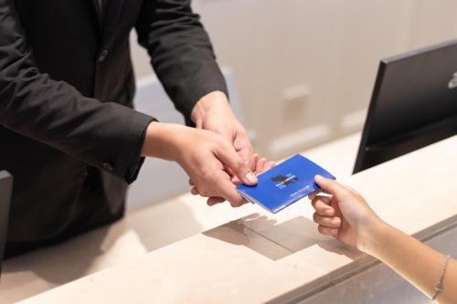 a man and a woman shaking hands at a counter at Blue Hippo & Red Crocodile Hotel in Bangna