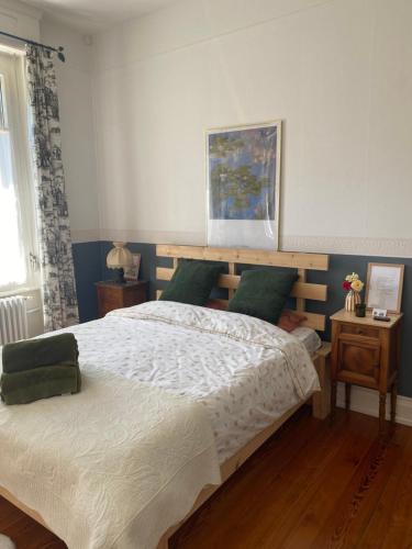 - une chambre avec un grand lit et des oreillers verts dans l'établissement La Maison du Markstein, à Linthal