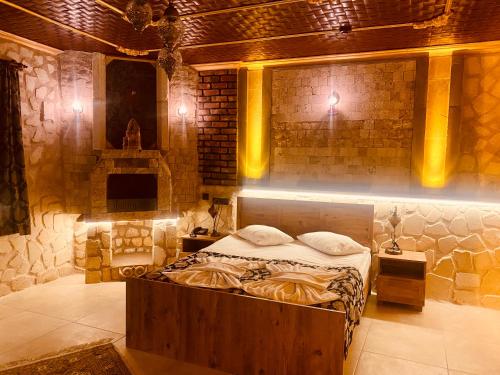 a bedroom with a bed in a room with a brick wall at Aysultan Stone House in Uchisar