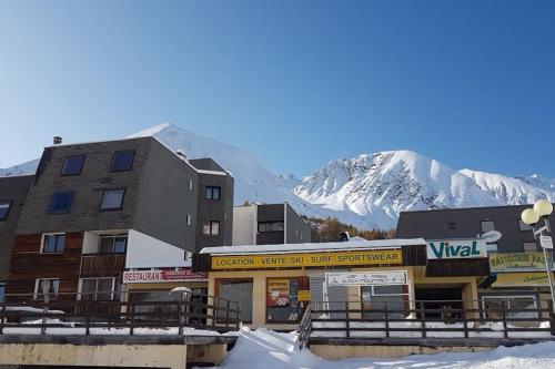 eine schneebedeckte Stadt mit einem Berg im Hintergrund in der Unterkunft Charmant studio refait à neuf in La Foux
