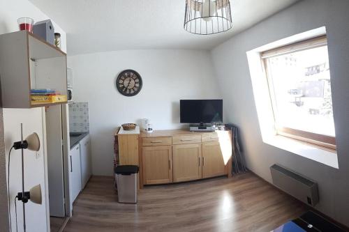 a kitchen with a desk with a television and a window at Charmant studio refait à neuf in La Foux