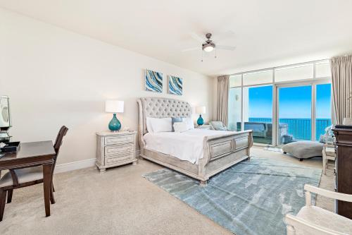a bedroom with a bed and a desk and windows at Turquoise 1908 C Turquoise Place in Orange Beach