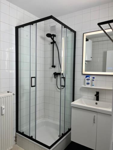 eine Dusche mit Glastür neben einem Waschbecken in der Unterkunft Appartement Justine in Blankenberge