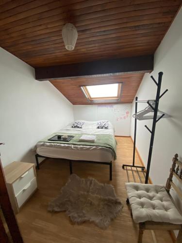 een slaapkamer met een bed en een houten plafond bij Chambre privée proche Geneve in Beaumont