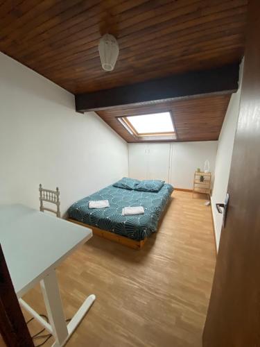 ein Schlafzimmer mit einem Bett und einem Tisch in einem Zimmer in der Unterkunft Chambre privée proche Geneve in Beaumont