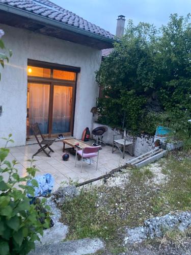 een patio met een tafel en stoelen voor een huis bij Chambre privée proche Geneve in Beaumont