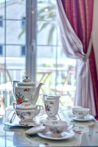 a tea set on a table with cups and saucers at Marinero Apartments in Budva