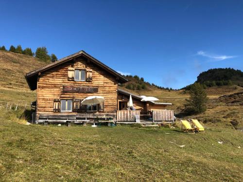 a log house on a hill in a field at Alp Jurte Skihütte Feldis in Feldis