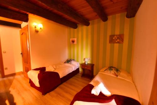 two beds in a room with green and white stripes at Balcon del Pirineo Rural Ordesa in Buesa