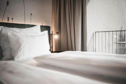 a bed with white sheets and a white pillow at SomVita Suites in Tirolo