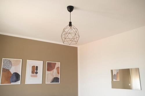 une lampe suspendue suspendue au-dessus d'une pièce avec des photos dans l'établissement Dimora Majella, à Civitella Messer Raimondo