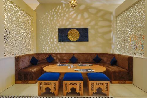 a dining room with a table and blue stools at Be Live Collection Saïdia in Saidia 