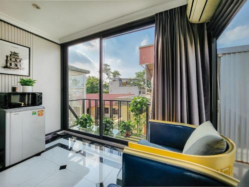 a living room with a large window and a blue chair at VietHOME Trang Tien in Hanoi