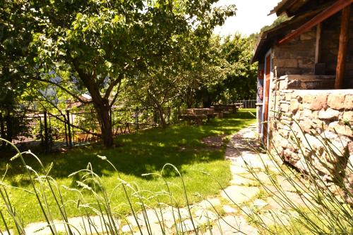 a yard with a stone building and a tree at Balcon del Pirineo Rural Ordesa in Buesa