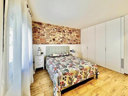 um quarto com uma cama e uma parede de tijolos em Ca La Nineta em Sant Feliu de Guíxols