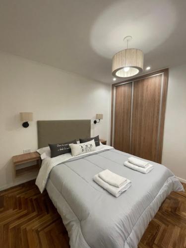 1 dormitorio con 1 cama grande y 2 toallas. en Lindo departamento, con excelente ubicación en Mar del Plata en Mar del Plata