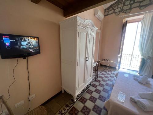 Habitación con TV en la pared y mesa. en Corso 41 en Bosa