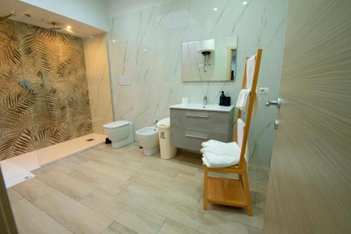 een badkamer met een wastafel, een toilet en een spiegel bij domus luì in Formia