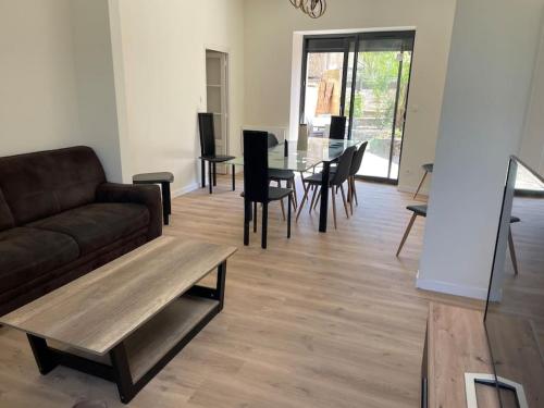 sala de estar con sofá, mesa y sillas en Maison 5 chambres 3sdb en ville avec piscine, en Périgueux