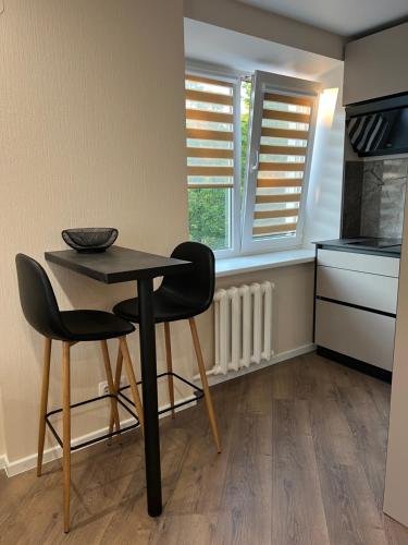 a small kitchen with a table and two chairs at Stradinya apartment in Ventspils