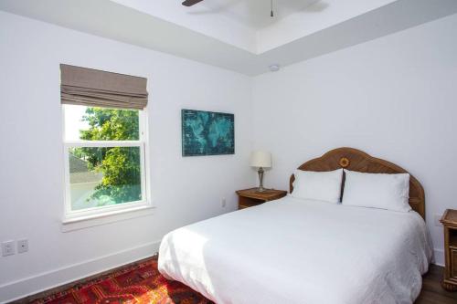 a white bedroom with a bed and a window at La Casa Boheme in Pensacola