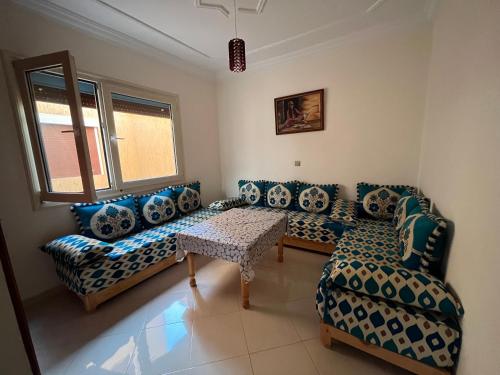 sala de estar con sofás y mesa en Joli appartement à Saïdia en Saidia 