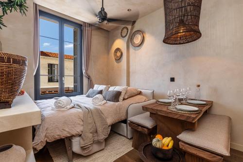 une chambre avec un lit, une table et une fenêtre dans l'établissement WABISABI SUITES - BRAILLE, à Cannes