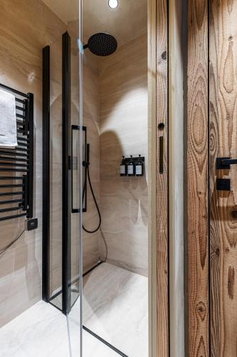 une douche avec une porte vitrée dans une salle de bain dans l'établissement WABISABI SUITES - BRAILLE, à Cannes
