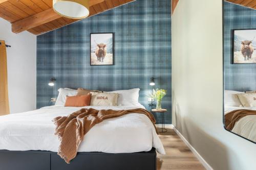 a bedroom with a bed and a blue wall at Highlands di TSS' - Esclusivo Appartamento - Appena Rinnovato - Ottimo per Famiglie a Levico Terme in Levico Terme