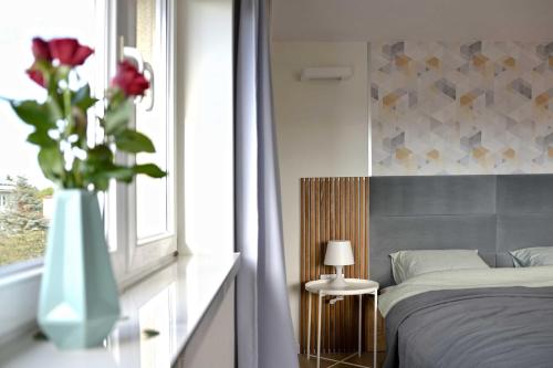 斯特迦納的住宿－Bursztynek，一间卧室,配有一张床,窗户上放着花瓶