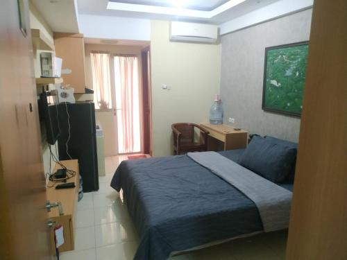 um quarto com uma cama, uma secretária e uma televisão em sewa kamar harian mingguan bulanan em Pondokcabe Hilir
