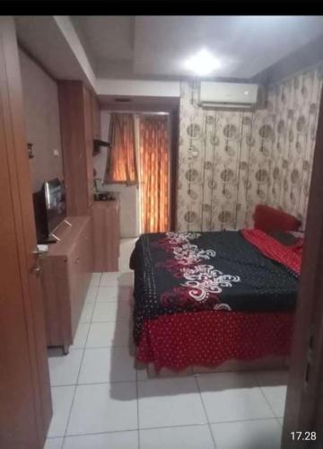 um quarto com uma cama e uma televisão em sewa kamar harian mingguan bulanan em Pondokcabe Hilir