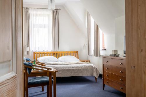 a bedroom with a bed and a chair and a dresser at Willa Bór in Zakopane