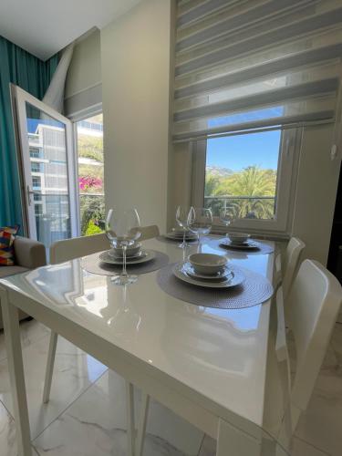 a dining room with a table with wine glasses on it at Calypso Residence Kestel in Alanya