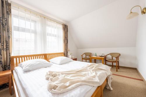 a bedroom with a bed with a white blanket on it at Willa Bór in Zakopane