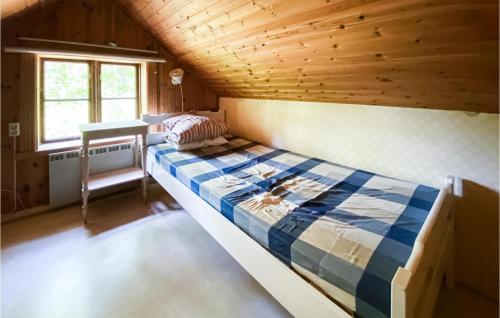 a bed in a room with a wooden ceiling at Beautiful Home In Mrdaklev With 3 Bedrooms in Mårdaklev