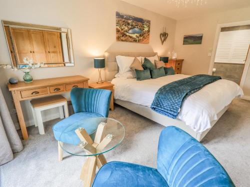 a bedroom with a bed and a table and chairs at Beech Lea in Ulverston